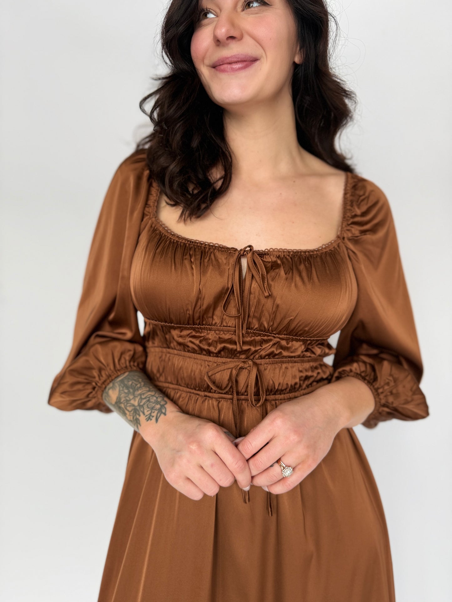 Woman wearing a brown dress against a white background