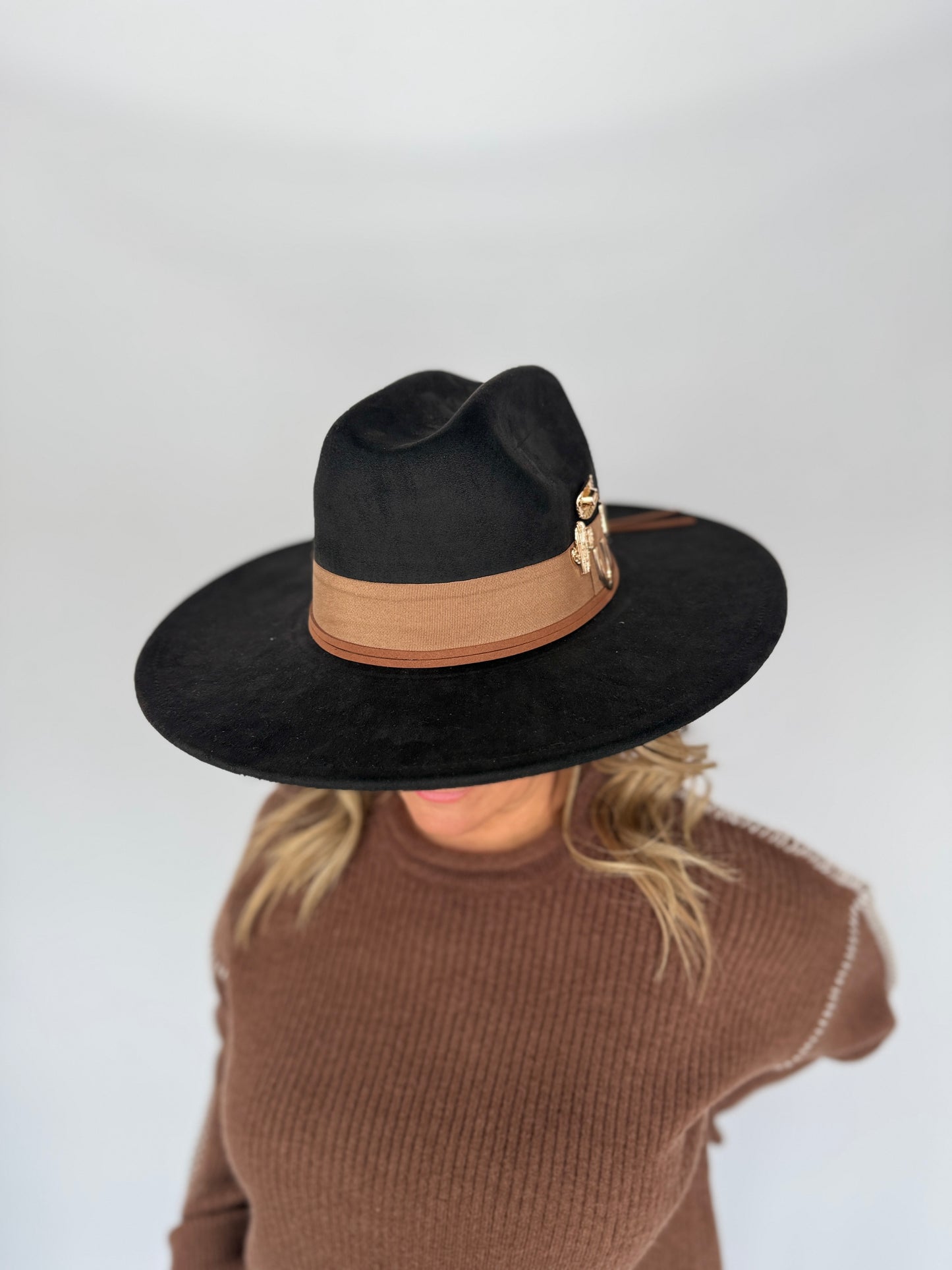 Person wearing a black hat with a brown band on a white background