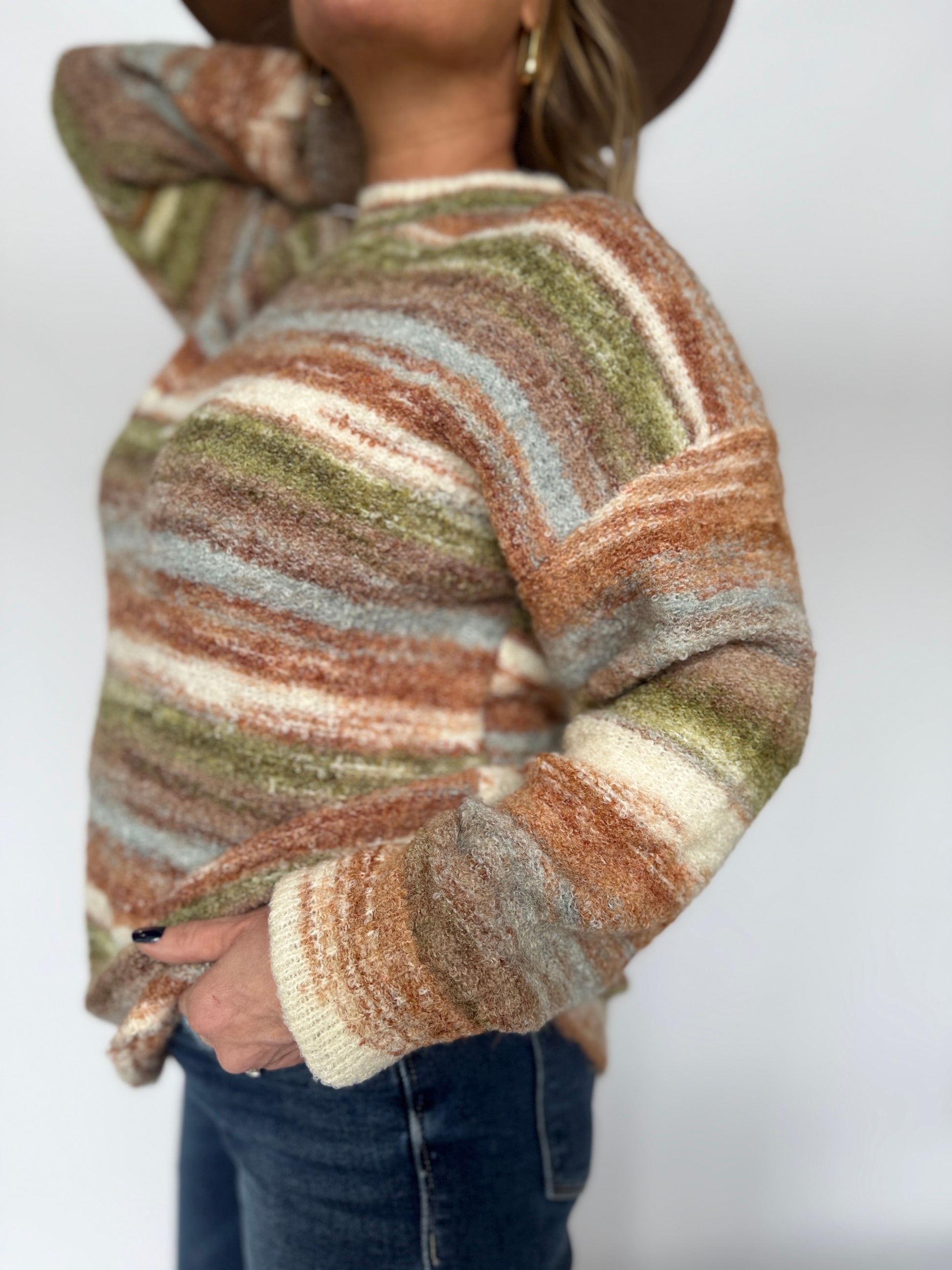 Person wearing a striped sweater with a neutral background