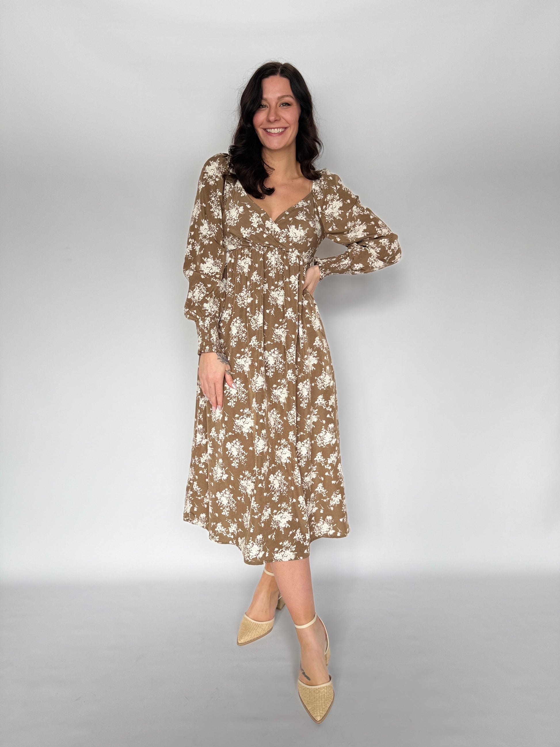 Woman wearing a floral dress against a plain background