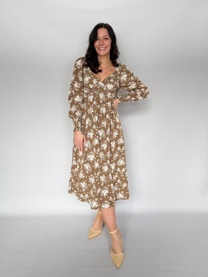 Woman wearing a floral dress against a plain background