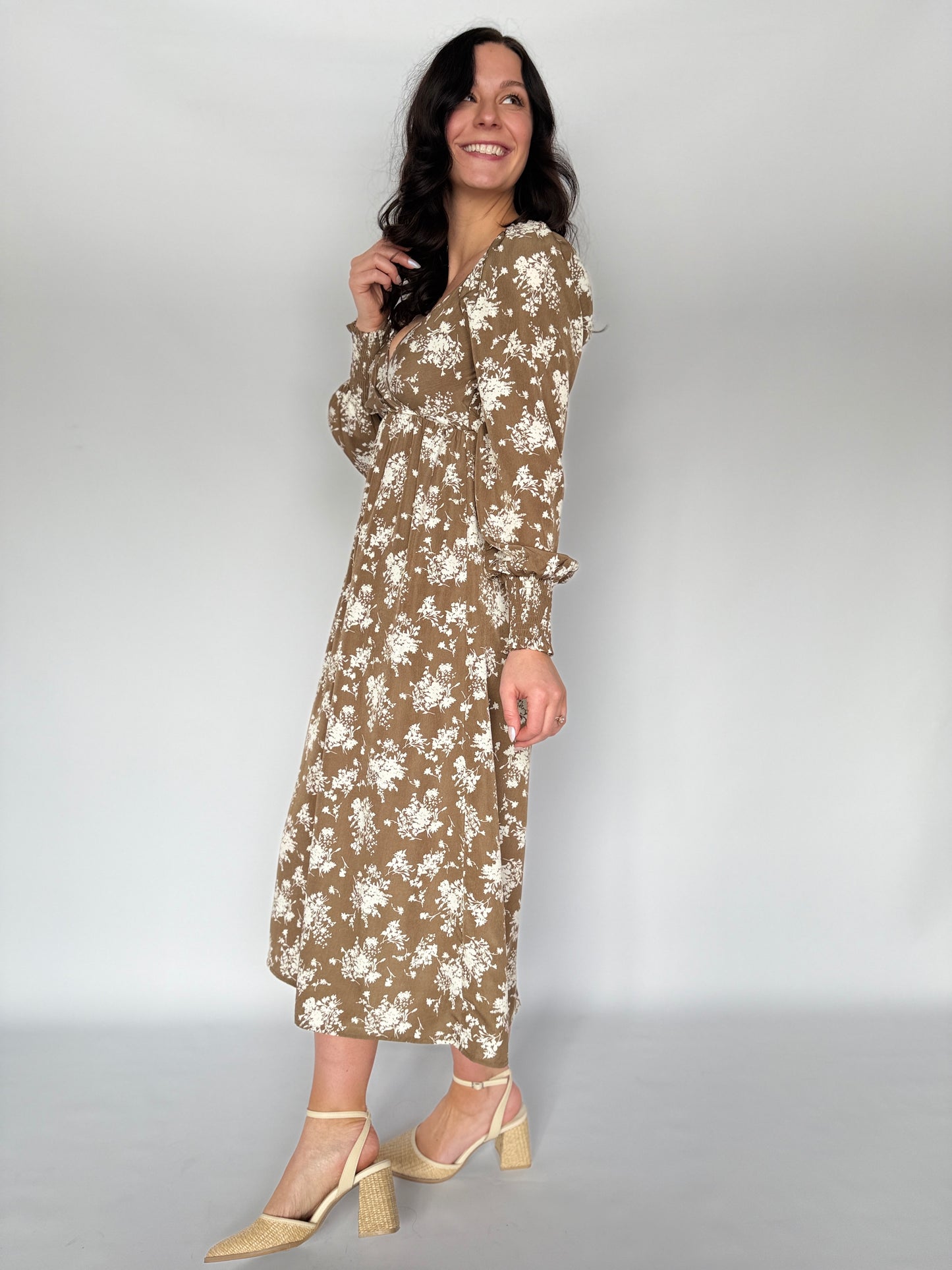 Woman wearing a floral dress against a plain background