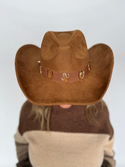 Person wearing a brown cowboy hat with a white background