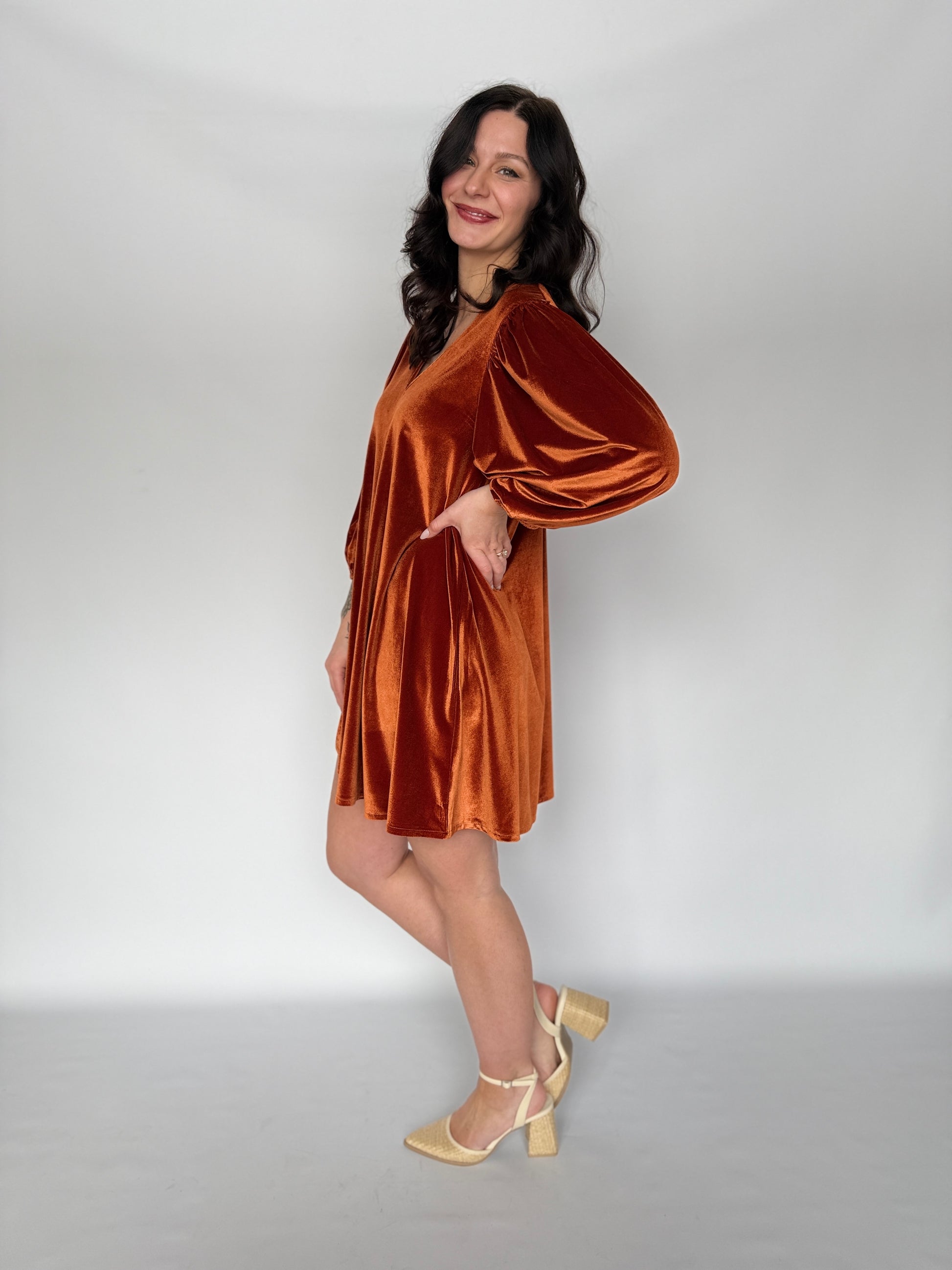 Woman wearing a brown velvet dress against a white background