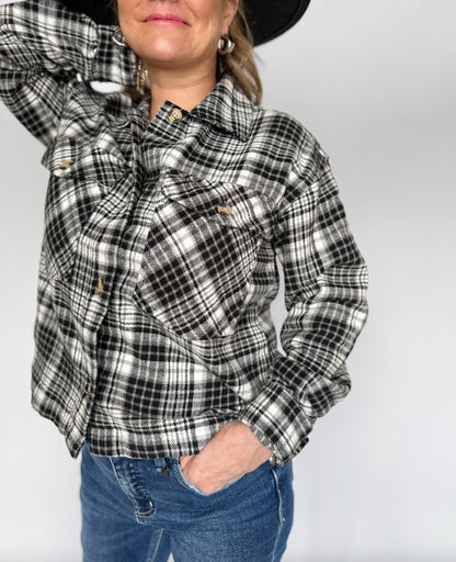 Person wearing a black and white plaid shirt with a plain background