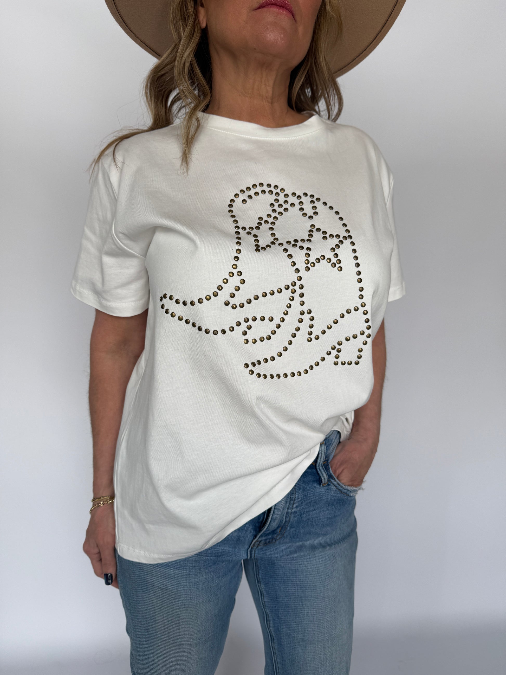 Person wearing a white sweatshirt with a black rhinestone design on a plain background